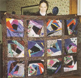
Daphne Taylor, holding Embellished Crazy Quilt, 1995. Machine-pieced, embellished with hand embroidery, beading and applique.
